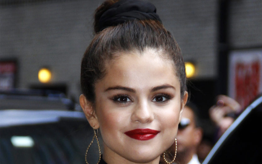 selena gomez wearing a scrunchie in a high braided ponytail