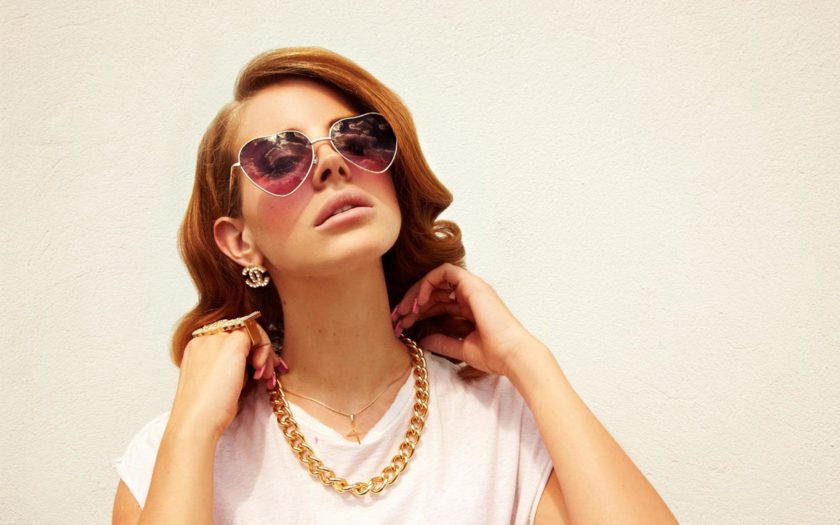 lana del rey in gold jewelry and heart shaped sunglasses