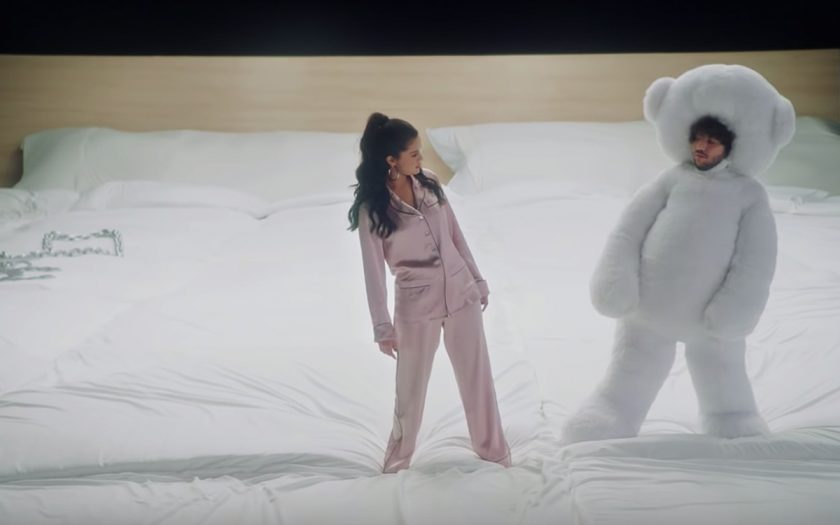 selena gomez and benny blanco standing on a giant bed