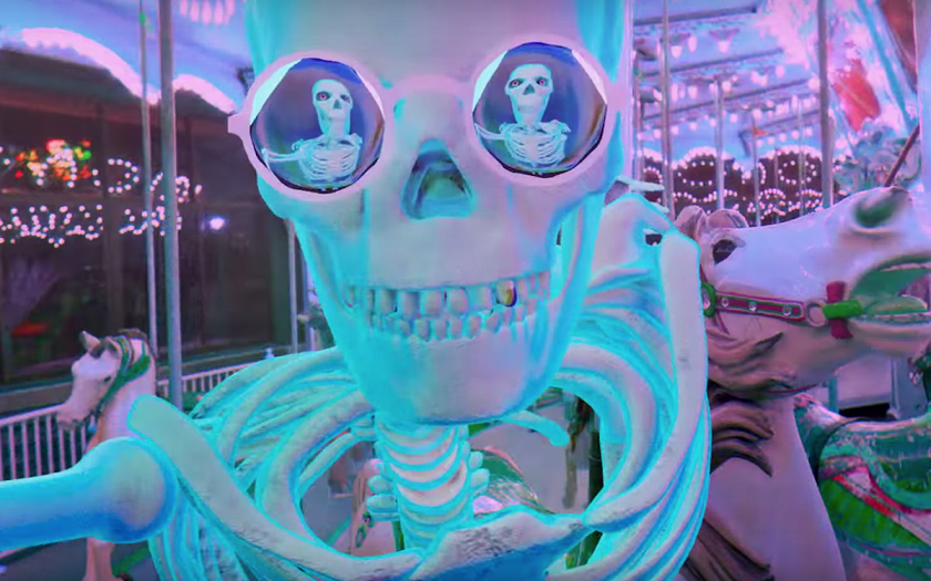 skeleton takes a selfie in kaleidoscope glasses while riding a merry go round