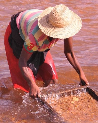 woman mines for minerals in a river