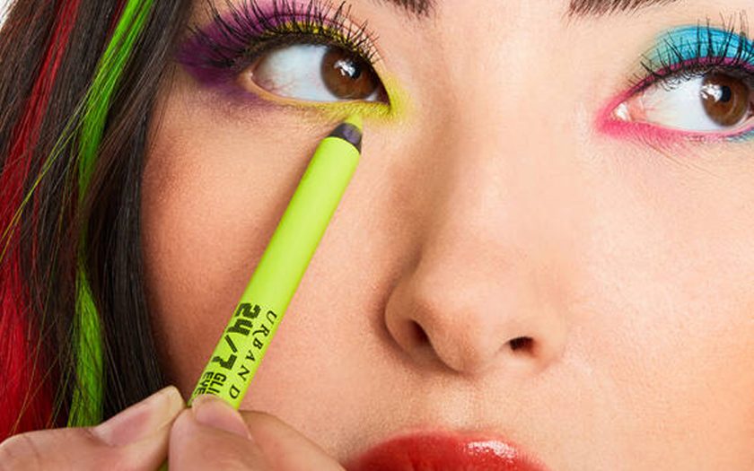 woman applies neon green eyeliner by urban decay